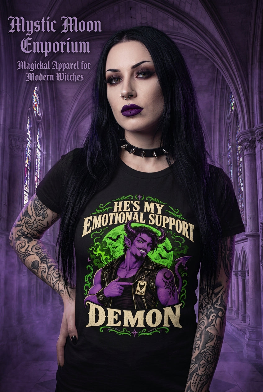 He's My Emotional Support Demon t-shirt — black Gildan G500 Heavy Cotton tee with a purple horned demon wearing a leather vest and ESD (Emotional Support Demon) badge, green moon and bats