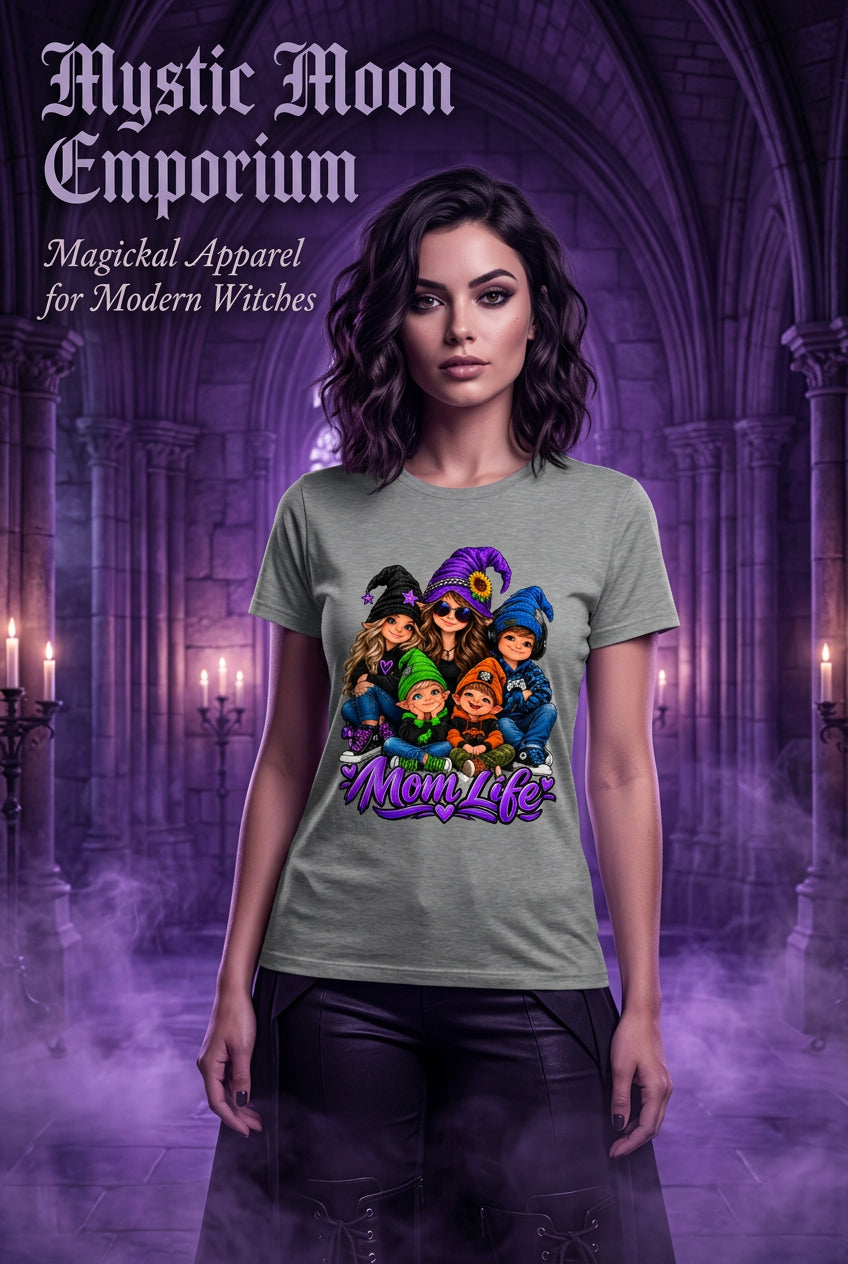 A heather gray short-sleeve t-shirt featuring a colorful cartoon graphic of five moms in witch hats with the text 'Mom Life' written below in purple script.