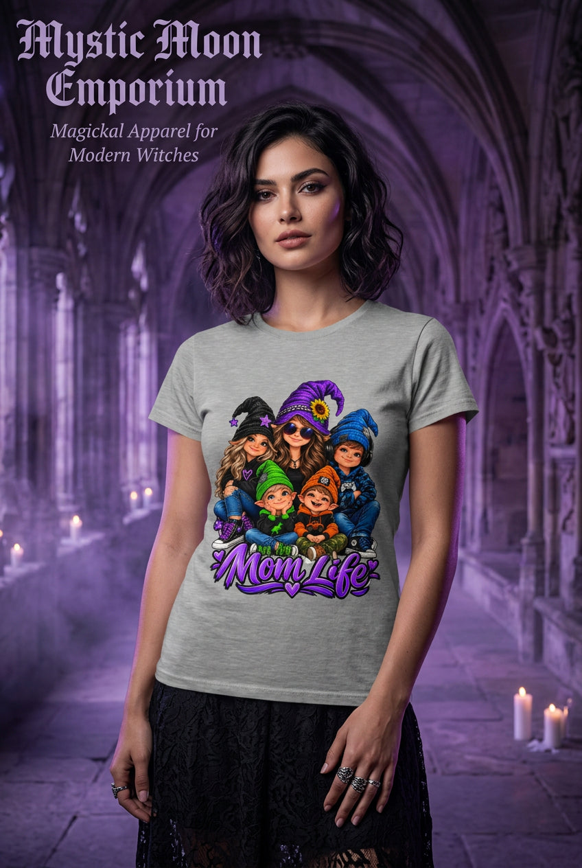 A heather gray short-sleeve t-shirt featuring a colorful graphic of cartoon characters dressed as witches and a mother with a pumpkin patch, with the text 'Mom Life' written in purple below them.